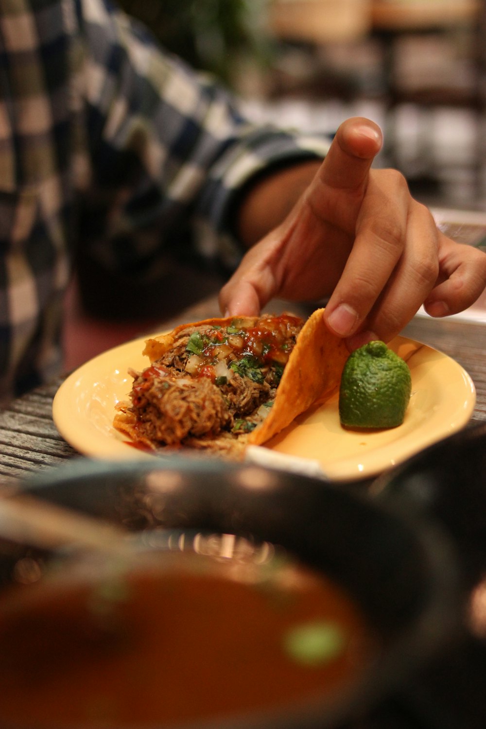 Stock photo of a birria taco being dipped in consomé